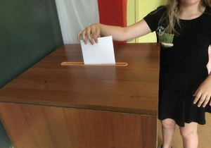 Uczennica wrzuca głos do urny podczas wyborów do SU