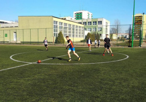 Uczniowie grają w piłkę nożną.