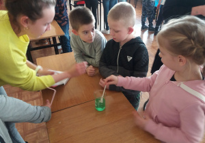 Dzieci wykonują doświadczenia fizyczne i chemiczne.