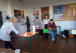 Nauczycielka prezentuje doświadczenia chemiczne.