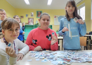 Uczennice przekazują znaczki fundacji misyjnej.