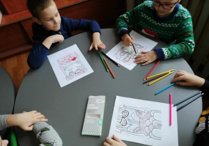 Dzieci kolorują obrazki.