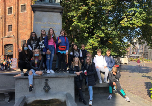 Uczniowie klasy 8 A pozują do zdjęcia przy pomniku Mikołaja Kopernika w Toruniu.