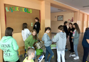 „Grupa ekologiczna” składająca się z uczniów Szkoły Podstawowej nr 12 przygotowuje kącik ekologiczny. Dzieci kleją, wycinają i przykleją napisy do tablicy korkowej.