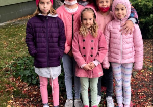 Dzieci z świetlicy stoją z nauczycielką przed budynkiem Szkoły Podstawowej nr 12.