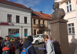 Uczniowie stoją przed pomnikiem Józefa Piłsudskiego w Koninie.