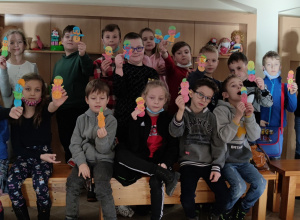 Sala warsztatowa Muzeum Okręgowego w Koninie. Uczniowie z klasy 2 c pokazują bałwanki wykonane z kolorowych opłatków.