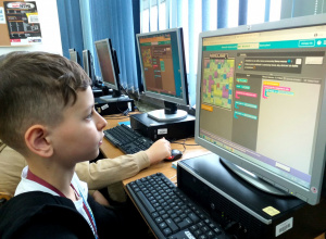 Chłopiec koduje ruch postaci na ekranie przy pomocy samouczków.