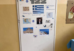 Widzimy drzwi do sali, na których widzimy flagę, zdjęcia zabytków, kontury map, zdjecie prezydenta Grecji.