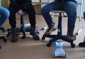 Robot podjeżdża do jednego z uczniów. Uczeń steruje robotem za pomocą aplikacji w telefonie.