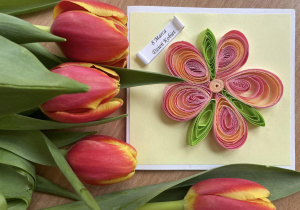 Kartka wykonana własnoręcznie z kolorowym kwiatkiem ułożonym z cienkich papierowych pasków i żółto - czerwone tulipany.