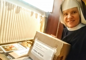 Siostra zakonna, która jest inicjatorką akcji w szkole, trzyma przygotowane paczki do wysyłki.