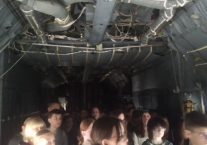 Grupa uczniów jest wewnątrz samolotu Hercules