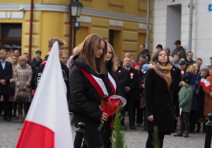 Uczennica Szkoły Podstawowej nr 12 w Koninie składa kwiaty pod pomnikiem Józefa Piłsudskiego.