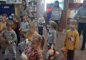 Grupa dzieci trzyma misie w rękach i uczestniczy w zabawie.