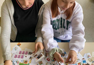 Dwie dziewczynki układają znaczki pocztowe.