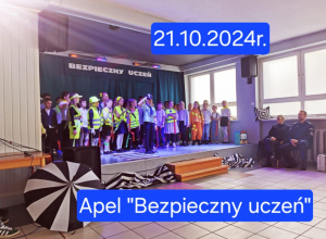 Uczniowie znajdują się na scenie. Poubierani są w kamizelki odblaskowe, jeden z nich stoi na przodzie w stroju policjanta. Po prawej stronie sceny siedzą zaproszeni policjanci.