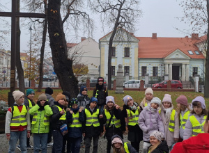 Uczniowie w kamizelkach odblaskowych znajdują się na starówce w Koninie.