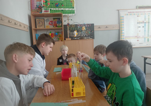 Uczniowie wykonują doswiadczenia chemiczne.