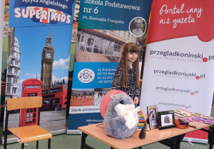 Uczennica podczas konkursu. Stoi przed stolikiem.
