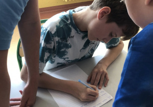 Uczniowie zapisują zapamiętany tekst dyktanda.