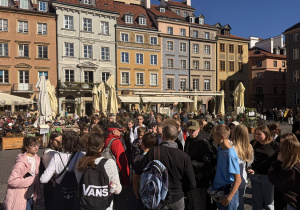 Uczniowie spacerują ulicami Warszawy.