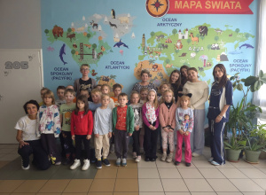 Grupa przedszkolaków przed fototapetą