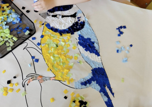 Dzieci ozdabiają sylwetkę ptaka.