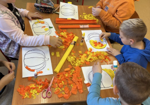 Uczniowie tworzą dynie z bibuły.