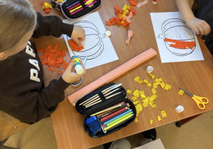 Uczniowie tworzą dynie z bibuły.