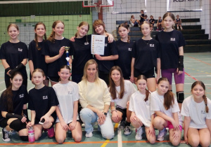 Wspólne zdjęcie szkolnej drużyny siatkarek wraz z opiekunem
